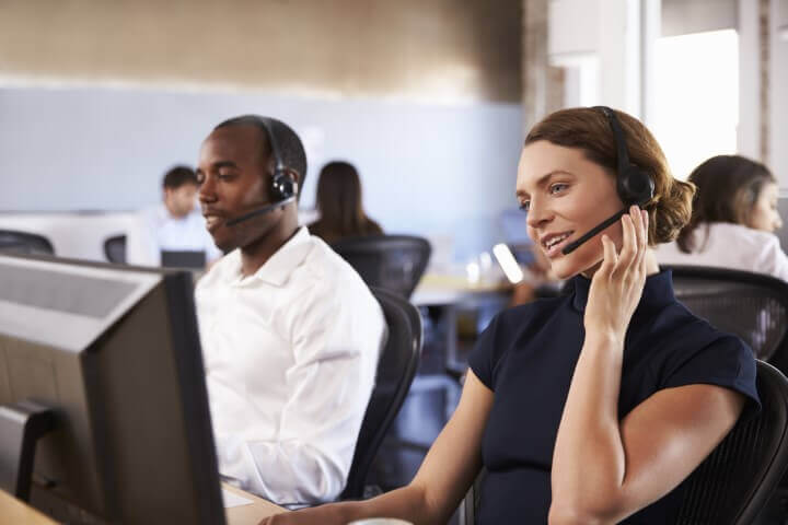 Staff wearing headsets in a busy customer service department